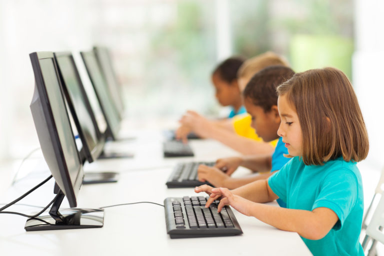 Elementary students typing on computer.